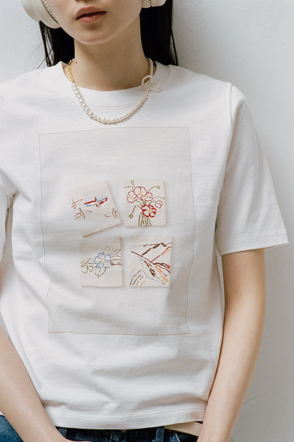 リーイズミダの4枚の絵「鳥」「ポピー」「山」「ツバキ」がプリントされたTシャツをモデルが着用