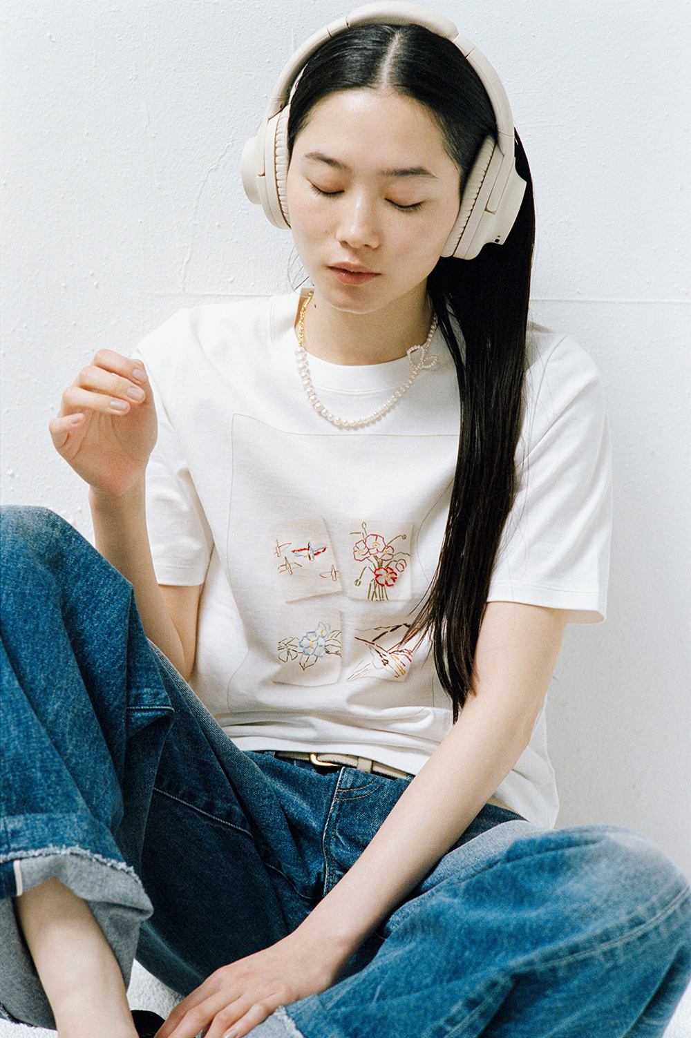 リーイズミダの4枚の絵「鳥」「ポピー」「山」「ツバキ」がプリントされたTシャツをモデルが着用