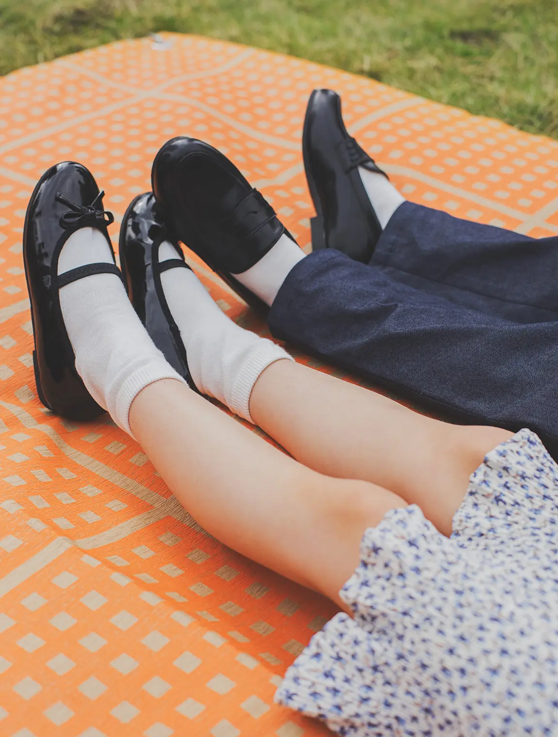 look02のモデル写真。女の子と男の子の足元が写っており、女の子は膝丈のワンピースに黒い靴、男の子はくるぶし丈のパンツに黒い靴を履いている